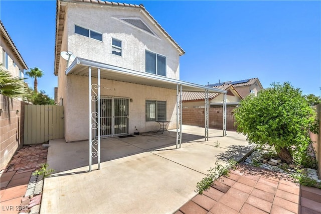 7977 Blue Brook Dr, Las Vegas, NV 89147 - rear view of house with stucco siding, a patio, and a fenced backyard
