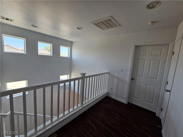 6824 Briarwood Bend Ave, Las Vegas, NV 89130 - hallway featuring dark wood-type flooring, a textured ceiling, an upstairs landing, and recessed lighting