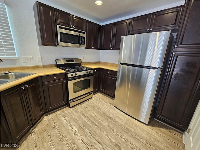 6824 Briarwood Bend Ave, Las Vegas, NV 89130 - kitchen featuring stainless steel appliances, light wood finished floors, light countertops, dark brown cabinets, and recessed lighting