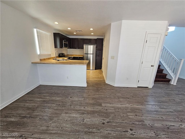 6824 Briarwood Bend Ave, Las Vegas, NV 89130 - kitchen with stainless steel appliances, dark wood-style flooring, a peninsula, light countertops, and recessed lighting