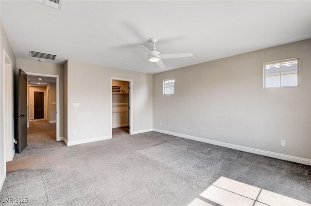 10556 Sariah Skye Ave, Las Vegas, NV 89166 - unfurnished bedroom with multiple windows, carpet flooring, ceiling fan, and a walk in closet