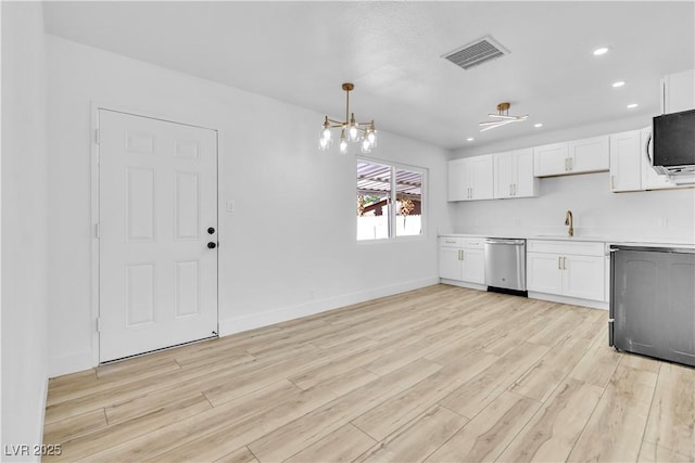 2105 Berkley Ave, Las Vegas, NV 89101 - kitchen with dishwasher, light wood-style floors, white cabinetry, light countertops, and a chandelier