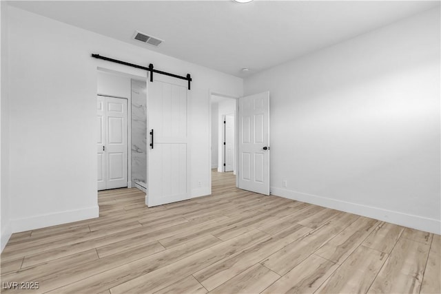 2105 Berkley Ave, Las Vegas, NV 89101 - unfurnished bedroom with light wood finished floors and a barn door