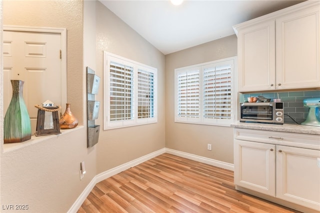 5733 Dazzling Sparks St, North Las Vegas, NV 89031 - unfurnished dining area featuring light wood-style floors and vaulted ceiling