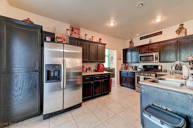 7137 Eyebright St, Las Vegas, NV 89131 - kitchen featuring appliances with stainless steel finishes, light tile patterned floors, light countertops, dark brown cabinetry, and recessed lighting