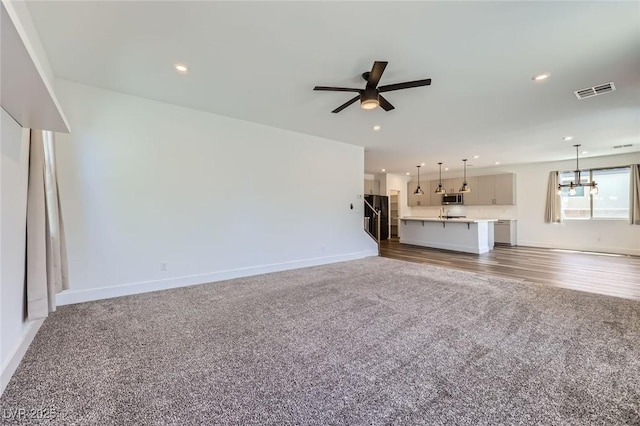 1213 Granite Falls Pl, North Las Vegas, NV 89084 - unfurnished living room featuring carpet flooring, ceiling fan, a chandelier, and recessed lighting