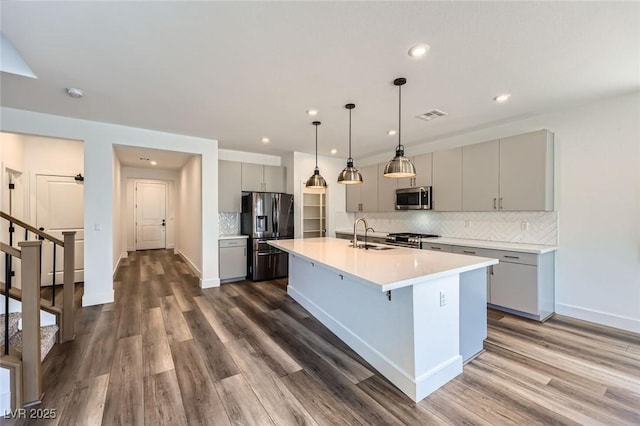 1213 Granite Falls Pl, North Las Vegas, NV 89084 - kitchen with appliances with stainless steel finishes, gray cabinetry, dark wood-style floors, decorative backsplash, and recessed lighting