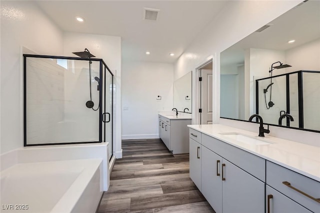 1213 Granite Falls Pl, North Las Vegas, NV 89084 - full bath featuring a shower stall, two vanities, wood finished floors, recessed lighting, and a garden tub