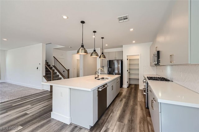 1213 Granite Falls Pl, North Las Vegas, NV 89084 - kitchen with appliances with stainless steel finishes, dark wood-type flooring, gray cabinetry, light countertops, and tasteful backsplash
