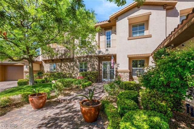2285 Villefort Ct, Las Vegas, NV 89117 - view of front of property with stucco siding, a tile roof, french doors, a balcony, and stone siding