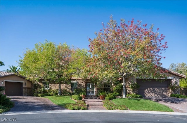 2285 Villefort Ct, Las Vegas, NV 89117 - view of property hidden behind natural elements with stone siding, driveway, french doors, an attached garage, and stucco siding