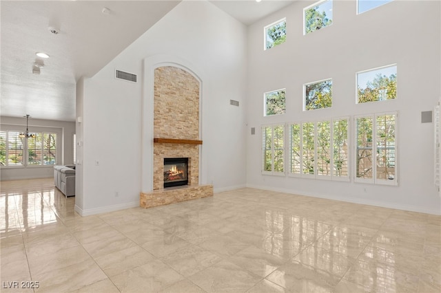 2285 Villefort Ct, Las Vegas, NV 89117 - unfurnished living room with a towering ceiling, a glass covered fireplace, and a chandelier
