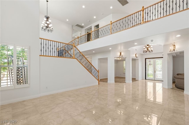 2285 Villefort Ct, Las Vegas, NV 89117 - unfurnished living room featuring a towering ceiling, a chandelier, stairs, marble tiled floors, and recessed lighting