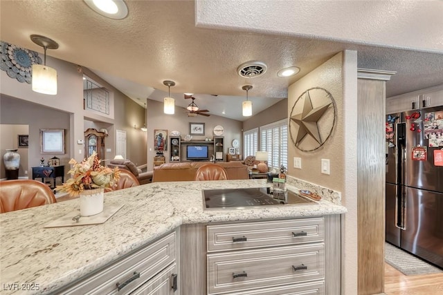 4045 N Chieftain St, Las Vegas, NV 89129 - kitchen with freestanding refrigerator, a textured ceiling, open floor plan, vaulted ceiling, and black electric cooktop