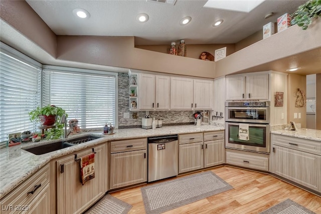 4045 N Chieftain St, Las Vegas, NV 89129 - kitchen with appliances with stainless steel finishes, decorative backsplash, light wood-style flooring, and light stone countertops