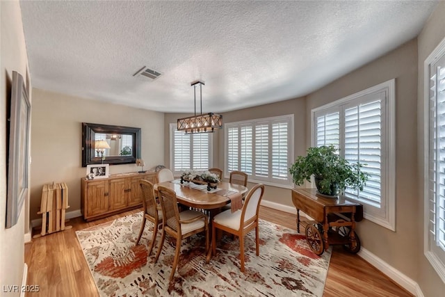 4045 N Chieftain St, Las Vegas, NV 89129 - dining room featuring light wood finished floors, a textured ceiling, and a chandelier