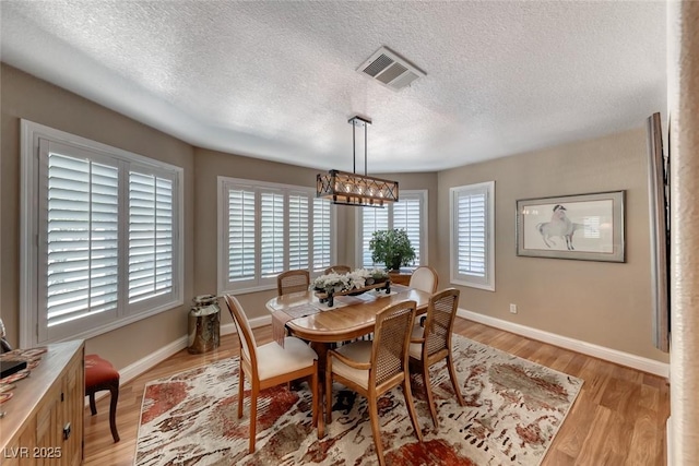 4045 N Chieftain St, Las Vegas, NV 89129 - dining space with a chandelier, a textured ceiling, and light wood-style floors