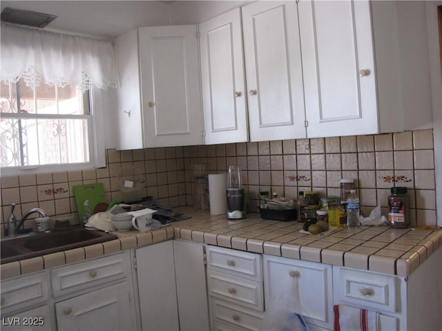 4950 Burnham Ave, Las Vegas, NV 89119 - kitchen with white cabinets and decorative backsplash