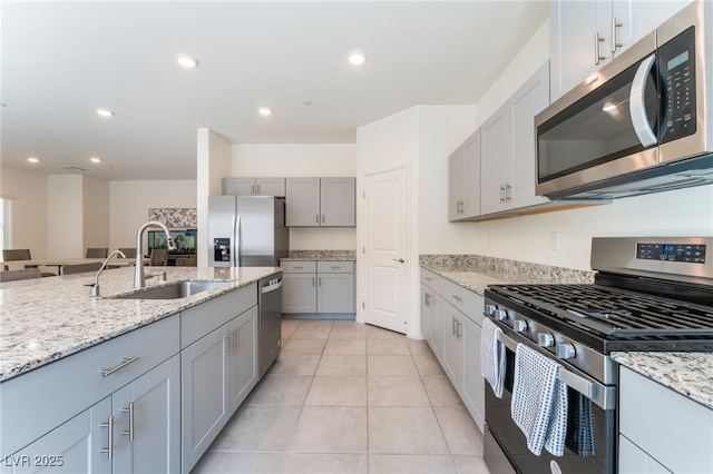 7211 Alabaster Peak St, Las Vegas, NV 89166 - kitchen featuring stainless steel appliances, gray cabinets, light stone counters, light tile patterned floors, and recessed lighting