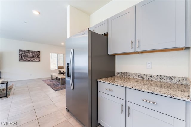 7211 Alabaster Peak St, Las Vegas, NV 89166 - kitchen with stainless steel fridge with ice dispenser, gray cabinets, light stone countertops, recessed lighting, and light tile patterned floors