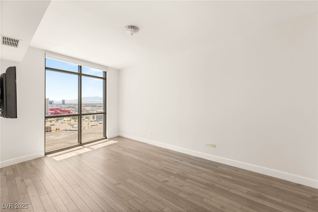 200 W Sahara Ave Unit 2204, Las Vegas, NV 89102 - spare room with floor to ceiling windows and wood finished floors