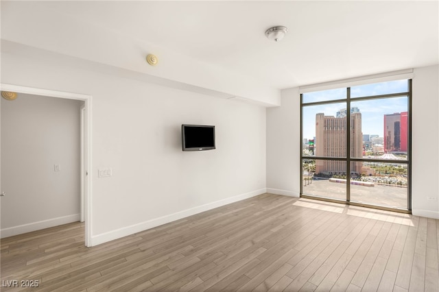 200 W Sahara Ave Unit 2204, Las Vegas, NV 89102 - empty room featuring expansive windows, wood finished floors, and a smoke detector
