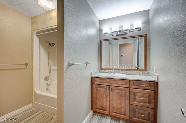 819 Sandsprings St, Henderson, NV 89011 - bathroom featuring vanity, wood finished floors, a textured wall, and shower / tub combination