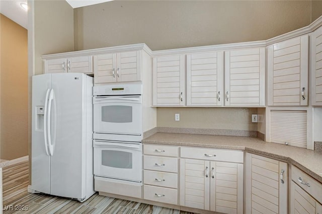 819 Sandsprings St, Henderson, NV 89011 - kitchen featuring white appliances, light countertops, white cabinets, and light wood-style floors