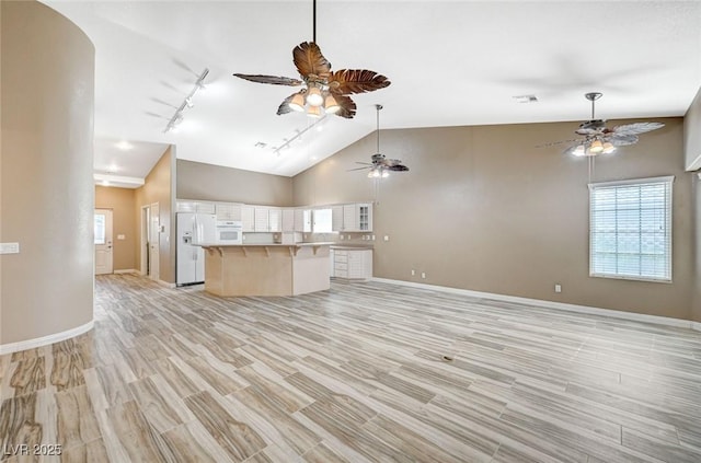 819 Sandsprings St, Henderson, NV 89011 - unfurnished living room with ceiling fan, rail lighting, healthy amount of natural light, light wood-type flooring, and high vaulted ceiling