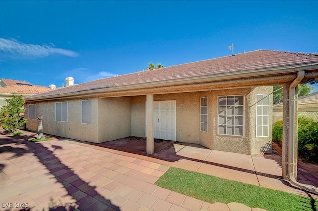 819 Sandsprings St, Henderson, NV 89011 - rear view of house featuring stucco siding, a patio, and roof with shingles