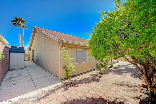819 Sandsprings St, Henderson, NV 89011 - view of property exterior with stucco siding, a patio area, and a storage shed