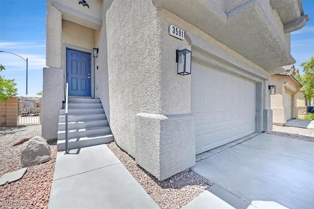 3591 Gloucester Gate St, Las Vegas, NV 89122 - view of exterior entry with a garage, stucco siding, and concrete driveway