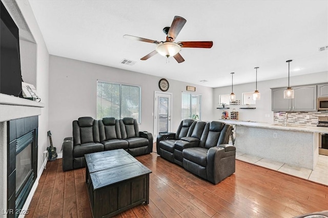 3591 Gloucester Gate St, Las Vegas, NV 89122 - living room with a ceiling fan, a glass covered fireplace, and wood-type flooring