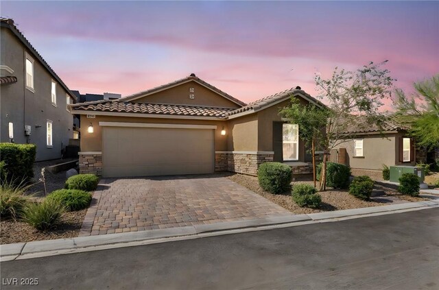 8346 Vinamala Ave, Las Vegas, NV 89149 - view of front of property featuring stone siding, a tile roof, stucco siding, and an attached garage