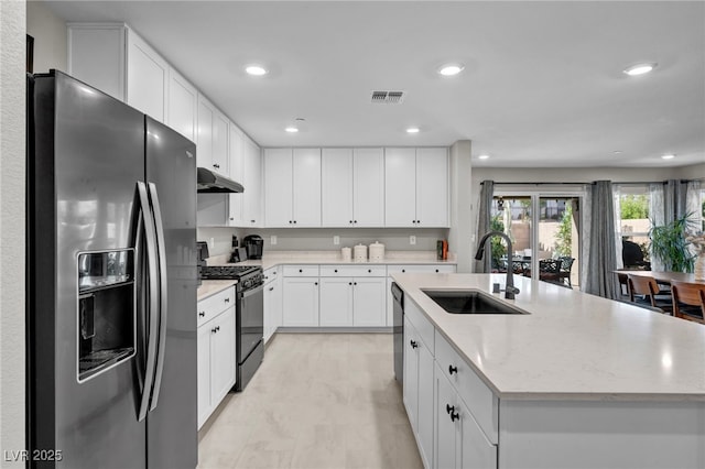 8346 Vinamala Ave, Las Vegas, NV 89149 - kitchen featuring stainless steel appliances, under cabinet range hood, a center island with sink, recessed lighting, and white cabinets