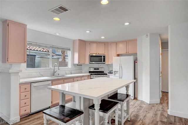 5823 Rose Sage St, North Las Vegas, NV 89031 - kitchen featuring stainless steel appliances, light brown cabinetry, light wood finished floors, a kitchen island, and recessed lighting