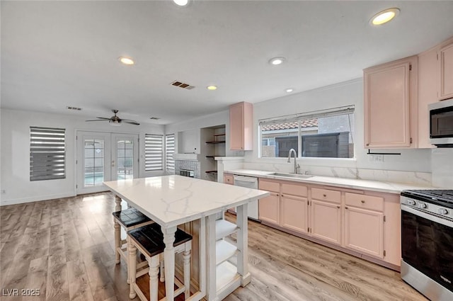 5823 Rose Sage St, North Las Vegas, NV 89031 - kitchen featuring appliances with stainless steel finishes, light wood-type flooring, recessed lighting, ceiling fan, and a breakfast bar