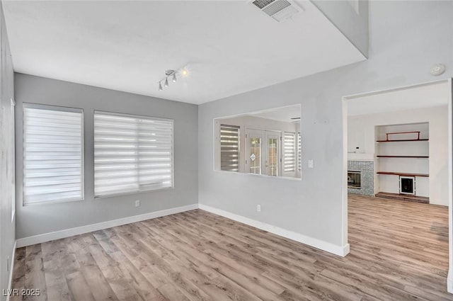 5823 Rose Sage St, North Las Vegas, NV 89031 - empty room featuring wood finished floors, a fireplace, healthy amount of natural light, and a smoke detector