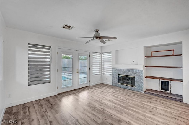 5823 Rose Sage St, North Las Vegas, NV 89031 - unfurnished living room featuring a tile fireplace, a ceiling fan, french doors, and wood finished floors