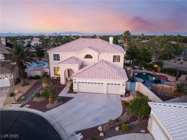 352 Angels Trace Ct, Las Vegas, NV 89148 - mediterranean / spanish-style house featuring an attached garage, driveway, stucco siding, and a tiled roof