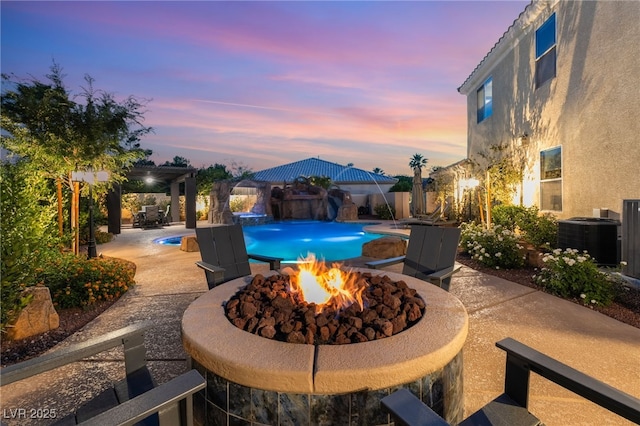 352 Angels Trace Ct, Las Vegas, NV 89148 - pool at dusk with an outdoor fire pit, a patio area, and a fenced backyard