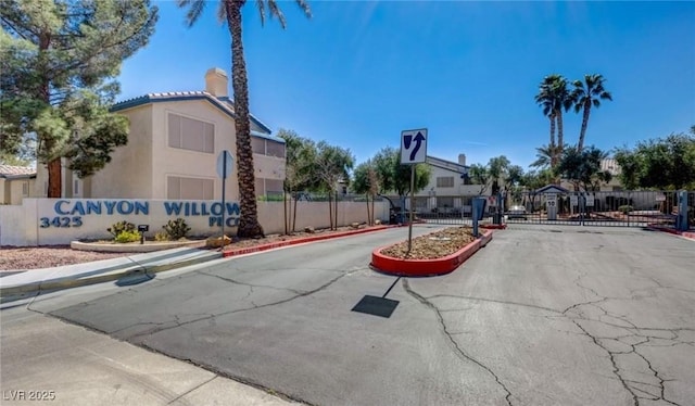 3425 E Russell Rd Unit 265, Las Vegas, NV 89120 - view of asphalt road featuring a gated entry, curbs, a gate, and sidewalks