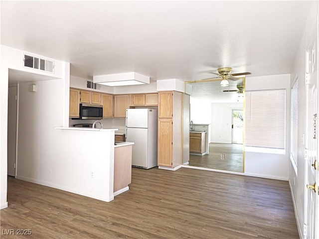 3425 E Russell Rd Unit 265, Las Vegas, NV 89120 - kitchen with freestanding refrigerator, stainless steel microwave, light countertops, and dark wood-style floors