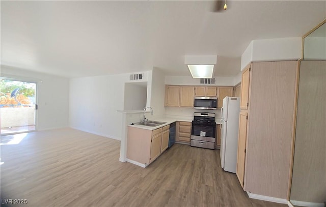 3425 E Russell Rd Unit 265, Las Vegas, NV 89120 - kitchen with appliances with stainless steel finishes, light brown cabinetry, light wood finished floors, light countertops, and a peninsula