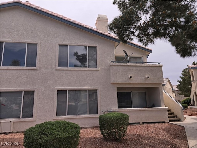 3425 E Russell Rd Unit 265, Las Vegas, NV 89120 - back of house with stucco siding, a chimney, a balcony, and a tile roof