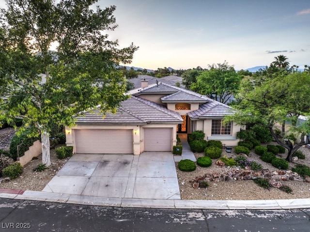 10300 Wellside Hill Ave, Las Vegas, NV 89145 - view of front facade with stucco siding, an attached garage, concrete driveway, and a tiled roof