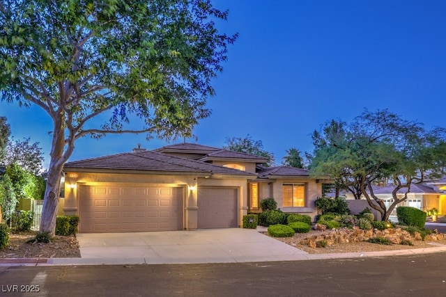 10300 Wellside Hill Ave, Las Vegas, NV 89145 - prairie-style house featuring an attached garage, driveway, a tile roof, and stucco siding