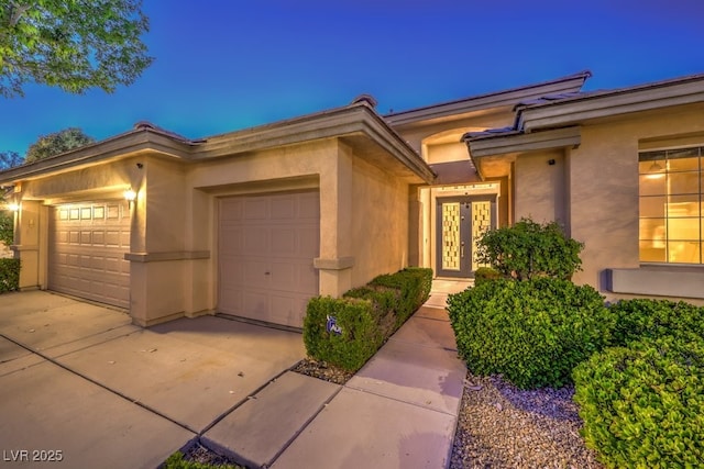 10300 Wellside Hill Ave, Las Vegas, NV 89145 - entrance to property featuring concrete driveway, stucco siding, an attached garage, and french doors