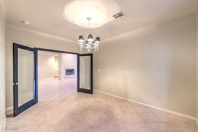 10300 Wellside Hill Ave, Las Vegas, NV 89145 - spare room featuring a chandelier, a smoke detector, a tile fireplace, and light tile patterned floors