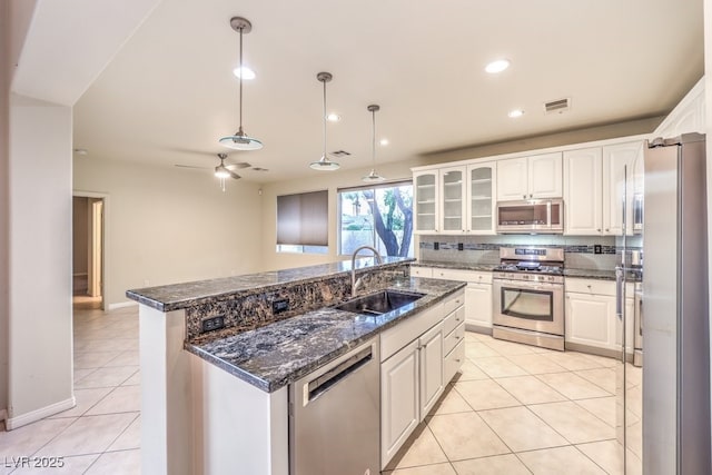 10300 Wellside Hill Ave, Las Vegas, NV 89145 - kitchen with appliances with stainless steel finishes, light tile patterned flooring, white cabinetry, a kitchen island with sink, and ceiling fan